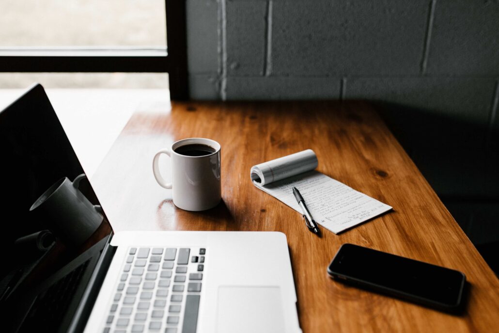 image of a laptop, coffee, mobile phone, and a checklist