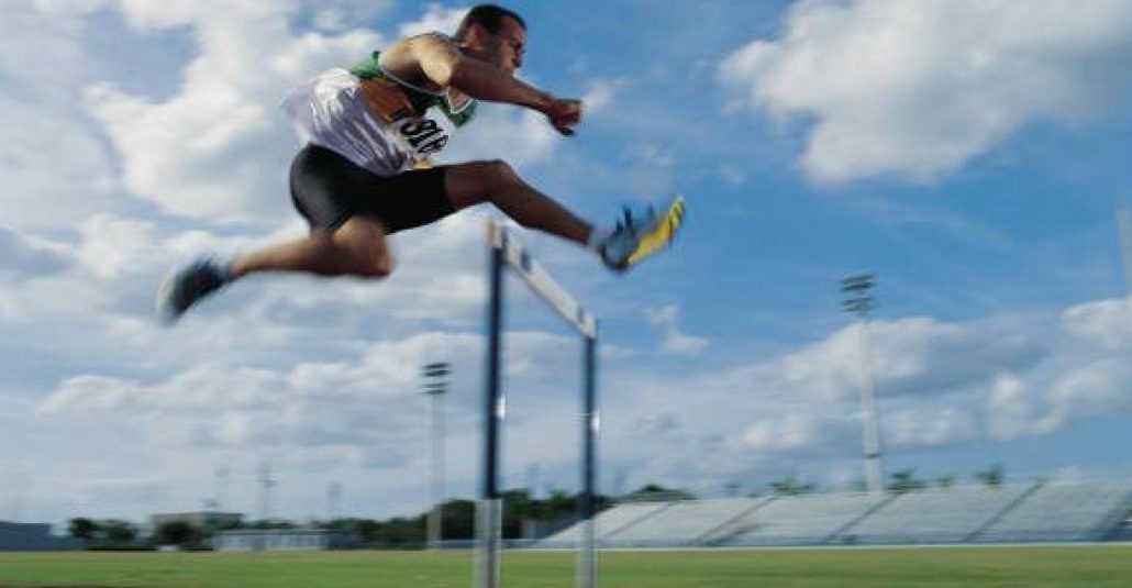 athlete jumping hurdles