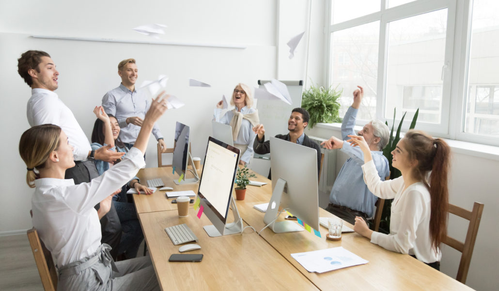 staff in a room throwing paper aeroplanes having a good time