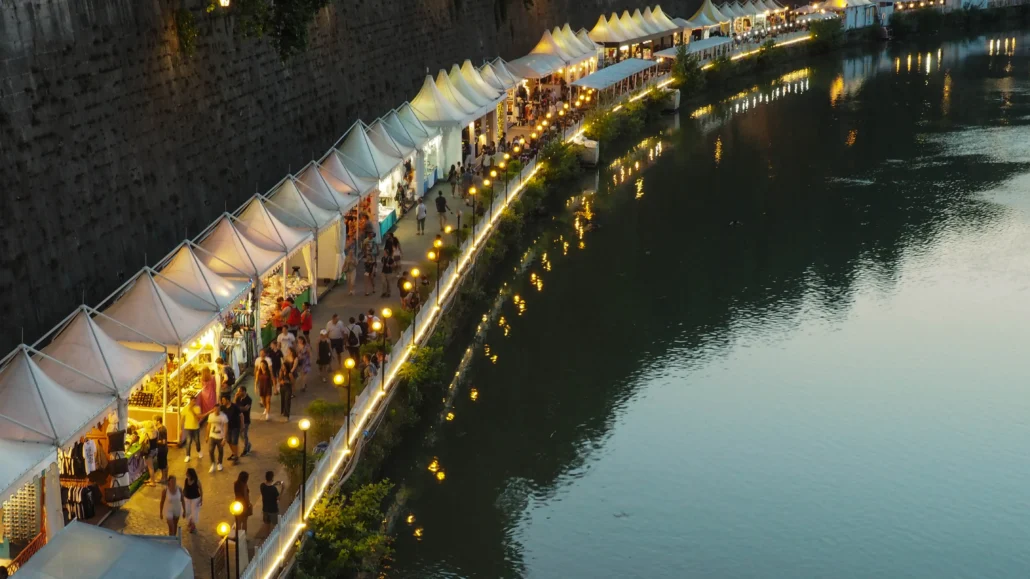 an image of market stalls next to a river