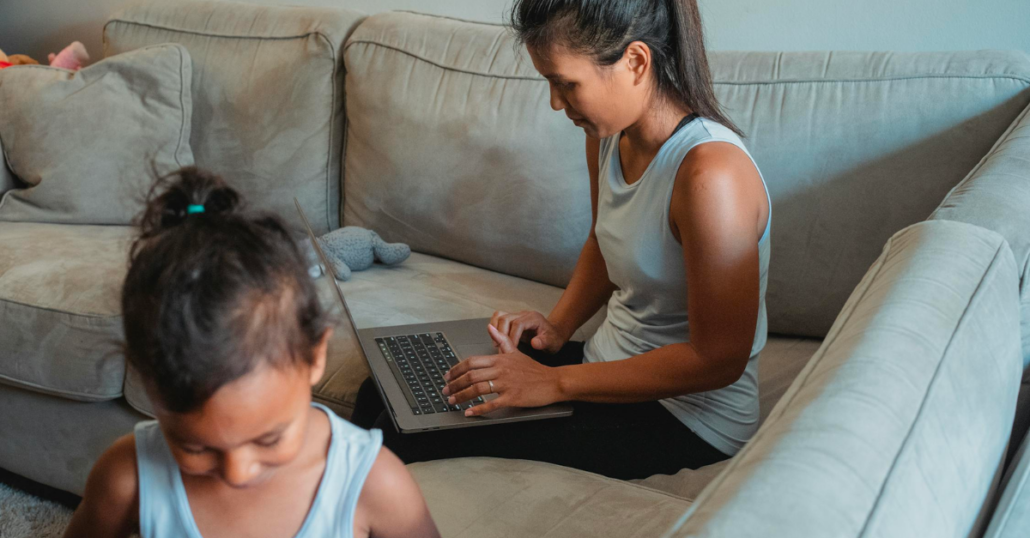 image of children on couch using laptop