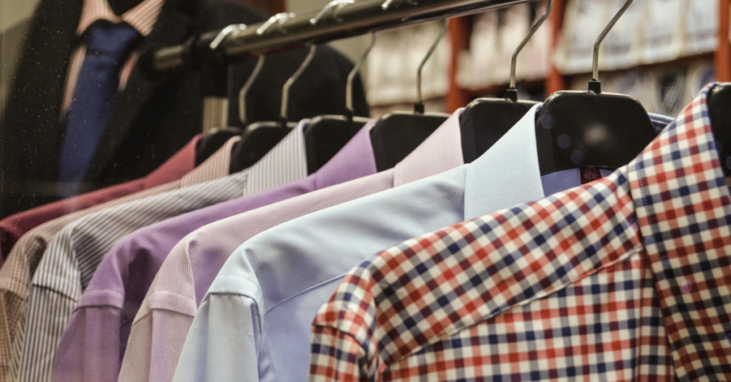 image of a rack of formal shirts of different colors and patterns on a hanging rail