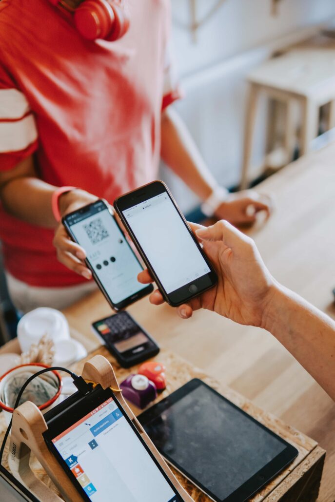 image of someone purchasing items at a store. They're paying on their mobile phone.