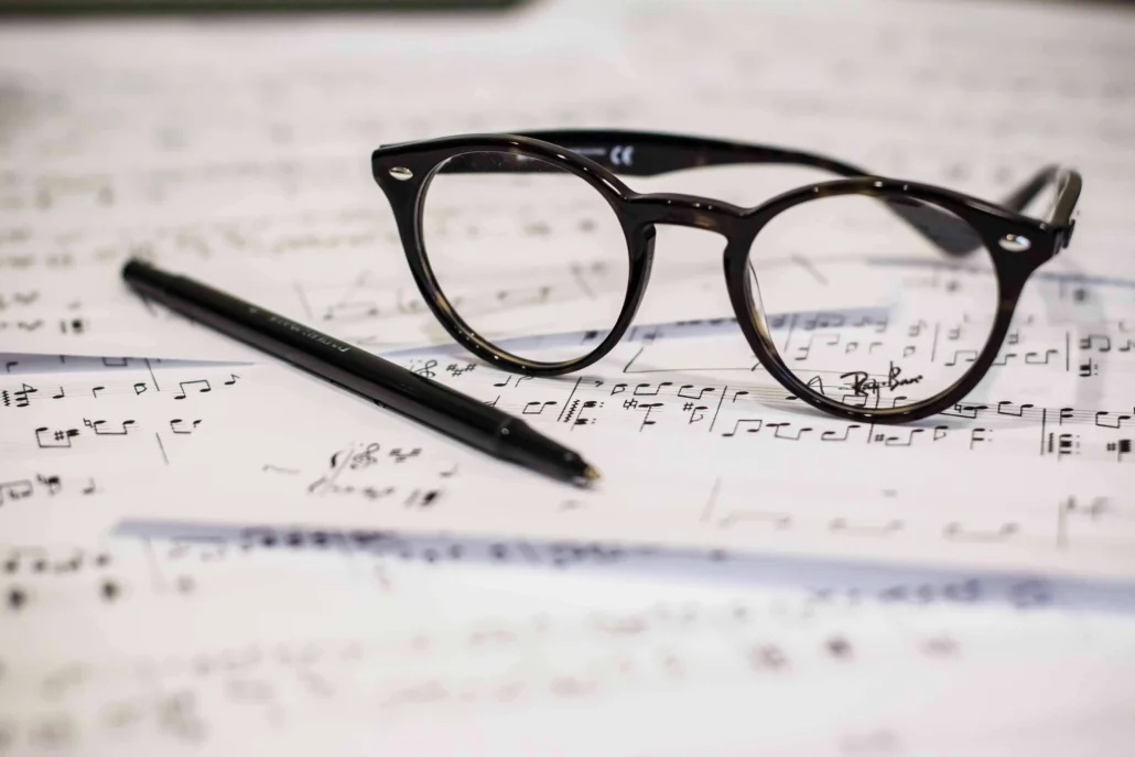 image of glasses and a pen on top of a music score