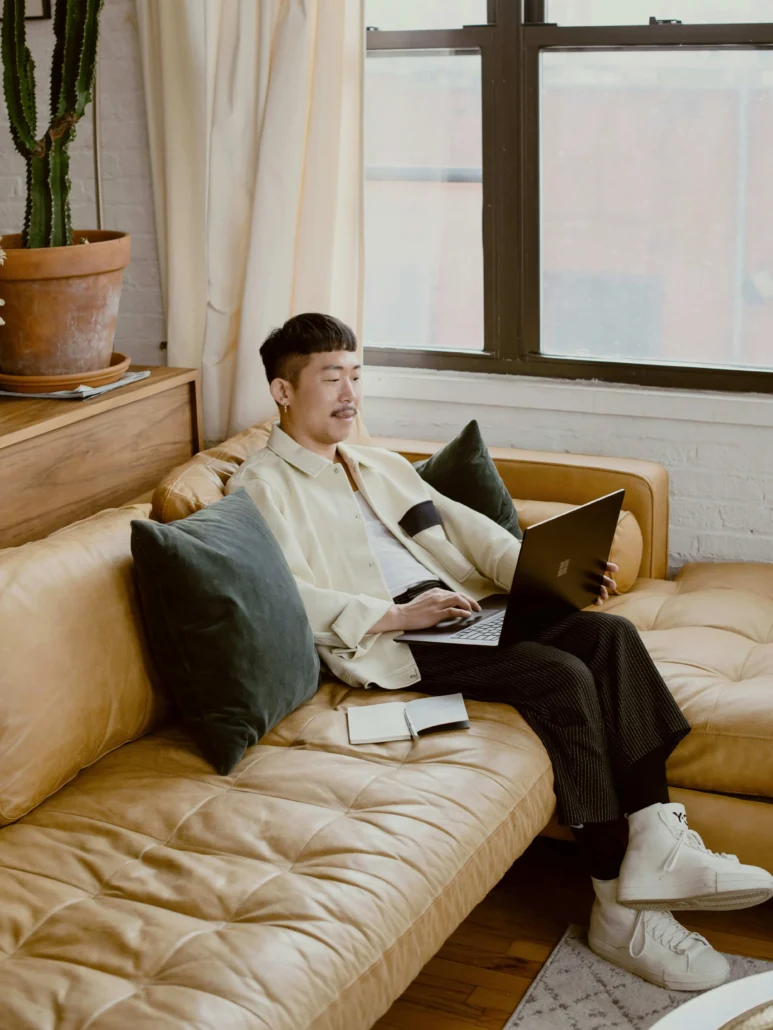 image of a man on a sofa working on a laptop